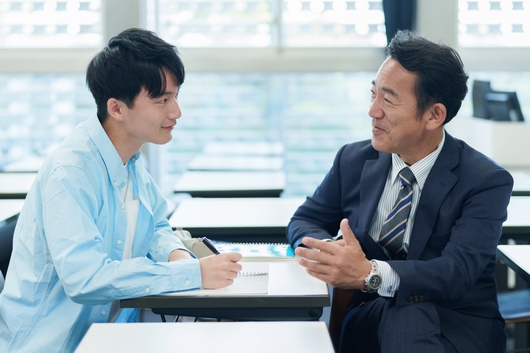 ひとりひとりにわかりやすく進路指導をしている先生と耳を傾ける生徒