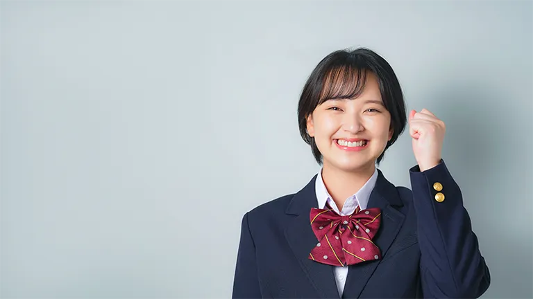 ガッツポーズで笑顔を見せる制服の高校生