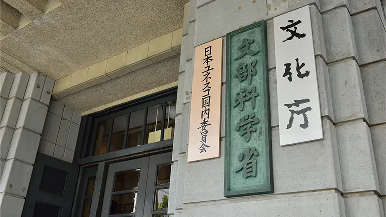 建物の石造りの壁に取り付けられた、「文部科学省」「文化庁」「日本ユネスコ国内委員会」の3つの看板。