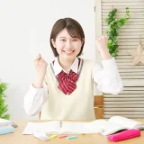 自信に満ちた笑顔でガッツポーズをする制服の高校生